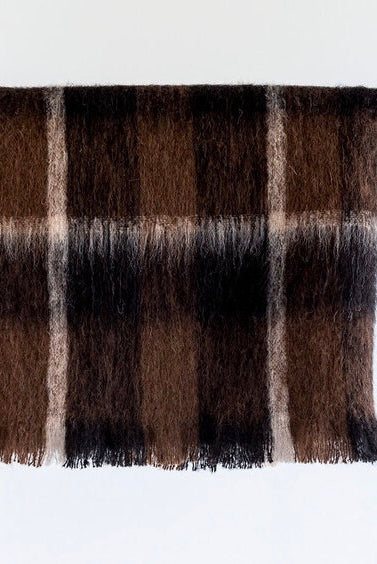 Folded Alpaca fleece throw in Buffalo colour on hanger.