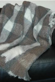 Alpaca fleece throw in Plateau colour draped on couch.