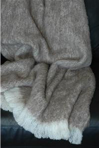 Alpaca fleece throw in Pumice colour draped on couch.