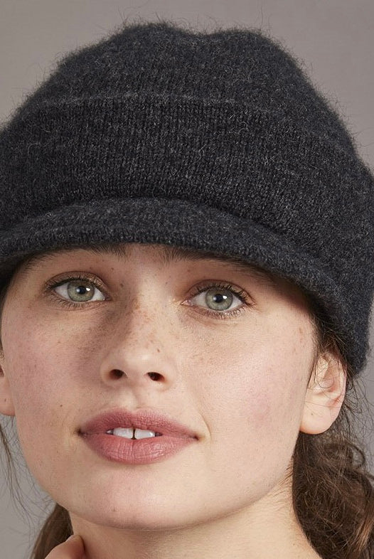 Woman wearing merino and possum cap with peak in charcoal
