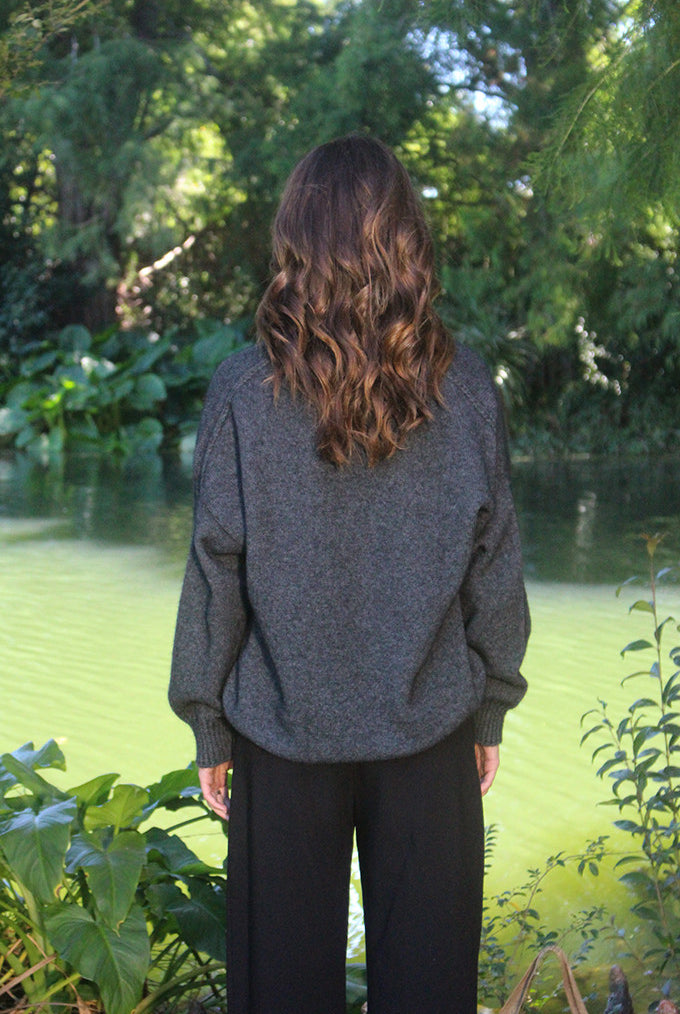 Woman wearing the Lothlorian - Merino & Possum Cavern V Neck Jumper (9789) in the colour Charcoal.