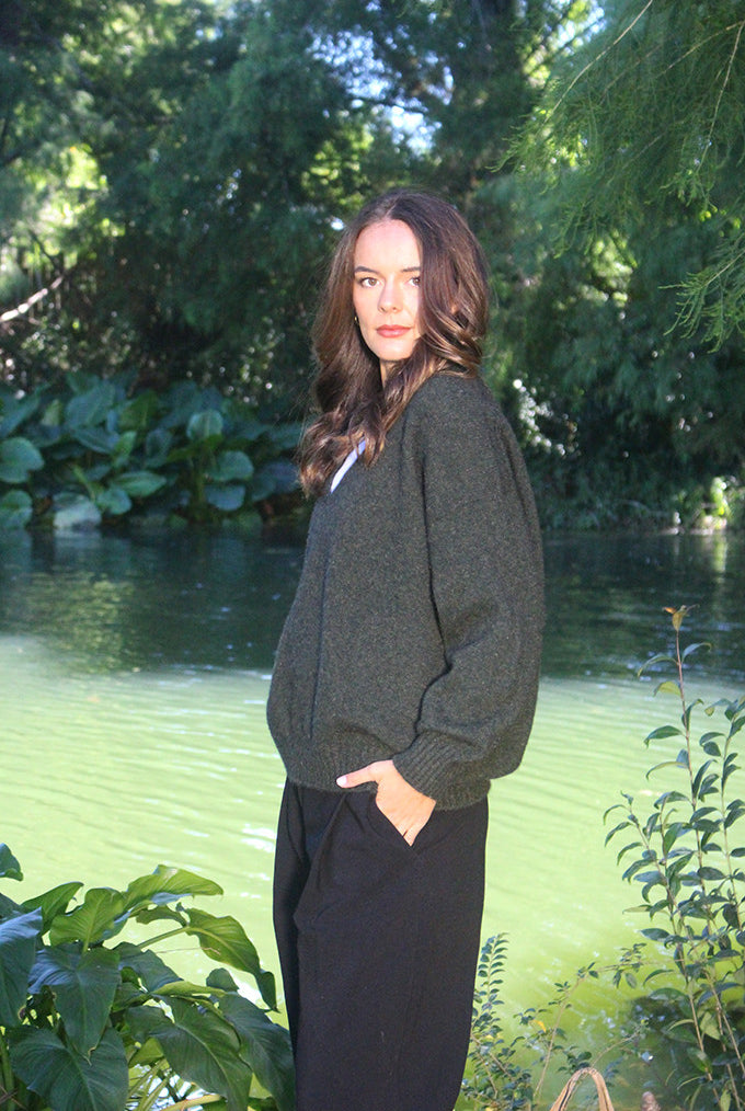 Woman wearing the Lothlorian - Merino & Possum Cavern V Neck Jumper (9789) in the colour Moss.