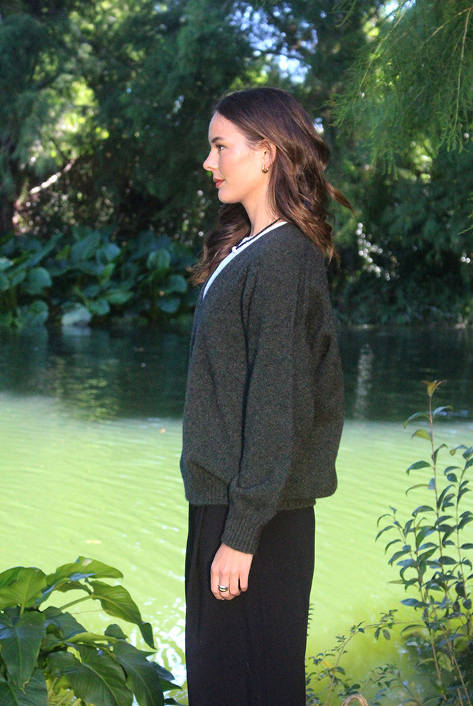 Woman wearing the Lothlorian - Merino & Possum Cavern V Neck Jumper (9789) in the colour Moss.