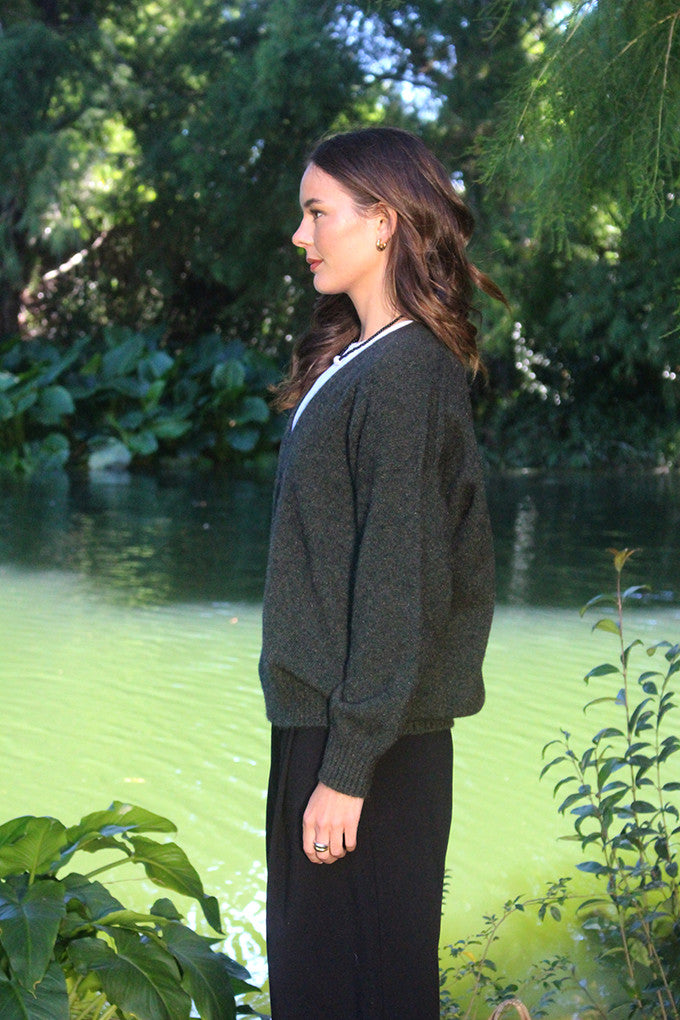 Woman wearing the Lothlorian - Merino & Possum Cavern V Neck Jumper (9789) in the colour Moss.