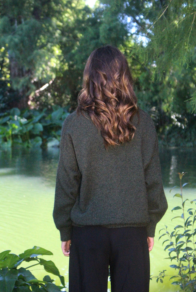 Woman wearing the Lothlorian - Merino & Possum Cavern V Neck Jumper (9789) in the colour Moss.