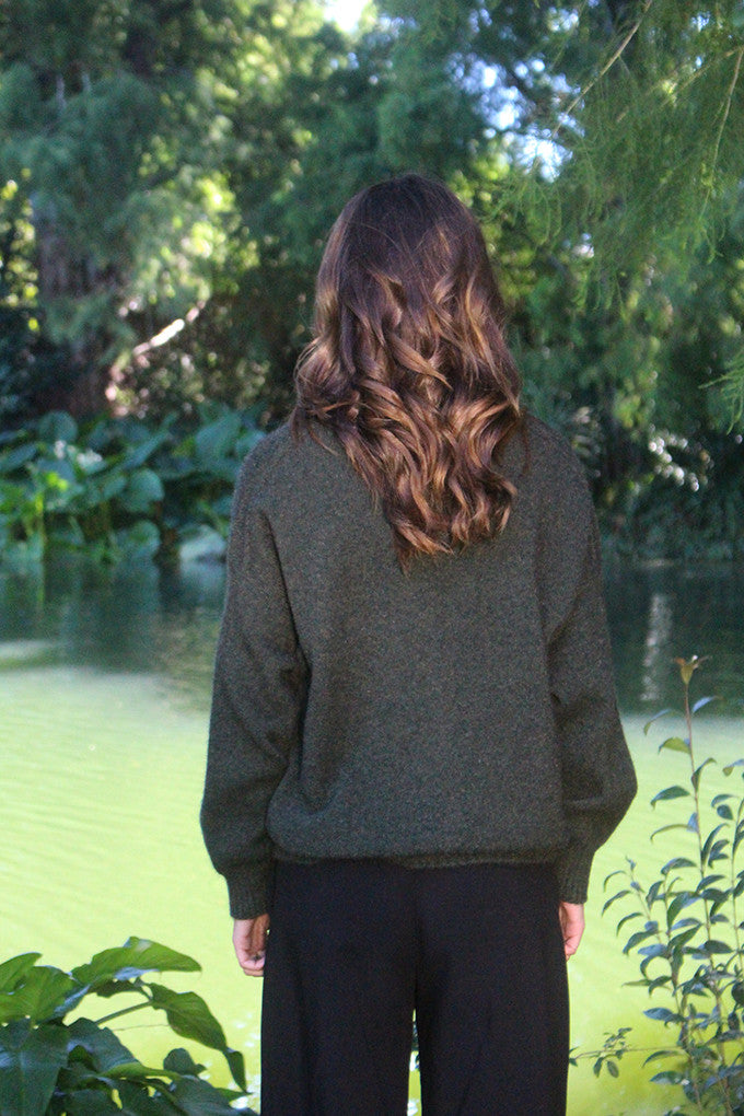 Woman wearing the Lothlorian - Merino & Possum Cavern V Neck Jumper (9789) in the colour Moss.