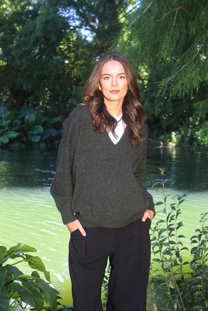 Woman wearing the Lothlorian - Merino & Possum Cavern V Neck Jumper (9789) in the colour Moss.