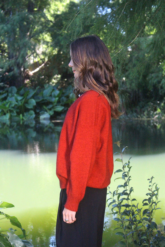 Woman wearing the Lothlorian - Merino & Possum Cavern V Neck Jumper (9789) in the colour Pumpkin.