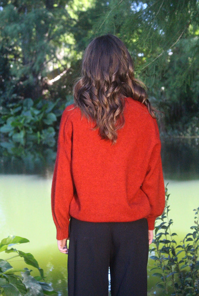 Woman wearing the Lothlorian - Merino & Possum Cavern V Neck Jumper (9789) in the colour Pumpkin.