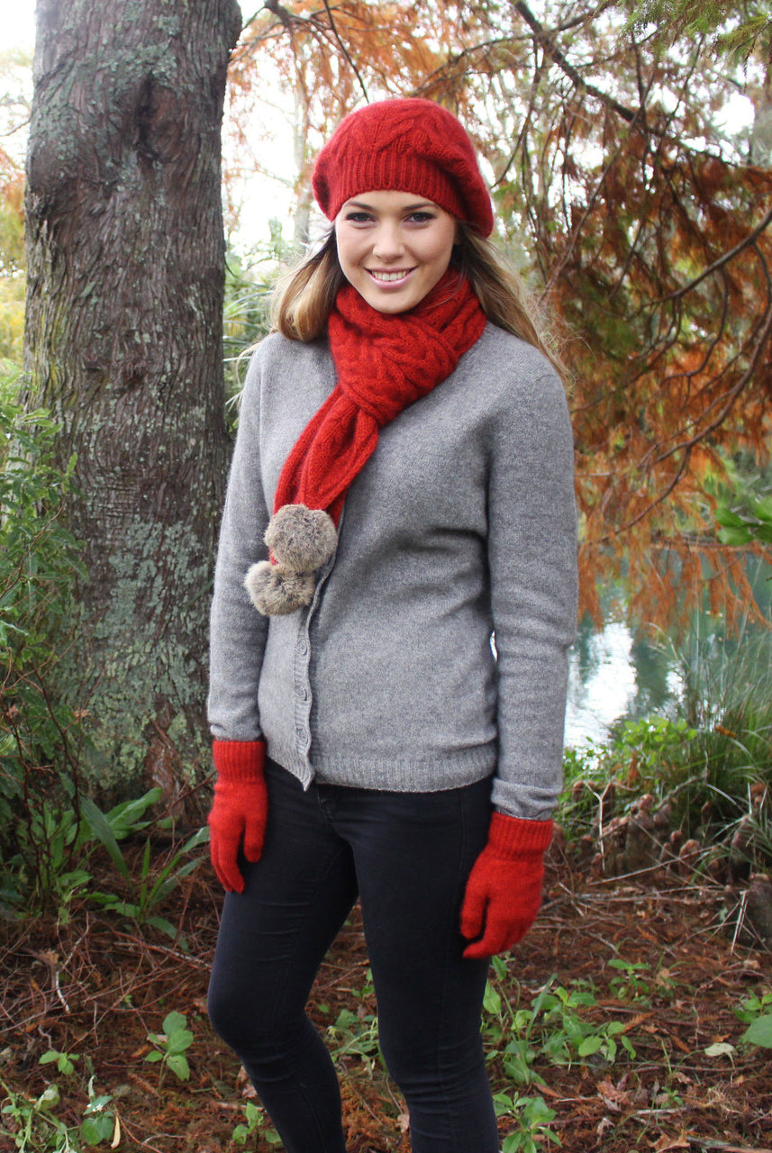 Full length image of woman wearing red beanie, scarf and gloves.