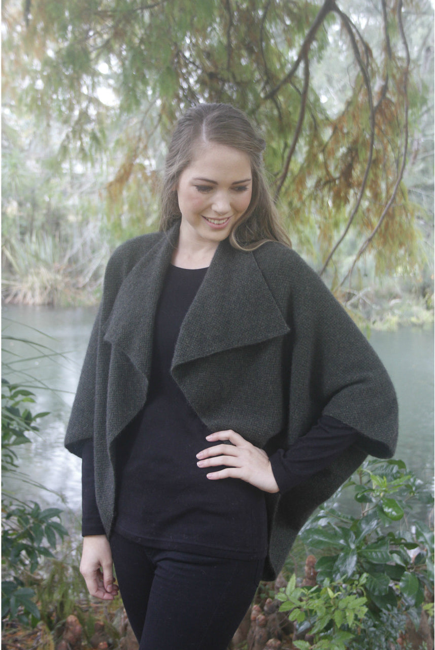 Woman wearing Takahe cape in colour Charcoal
