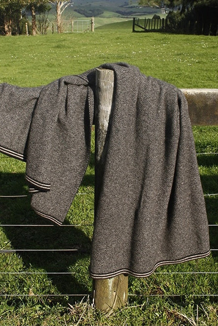 Lightweight blanket folded on fence. Colour Black/Natural