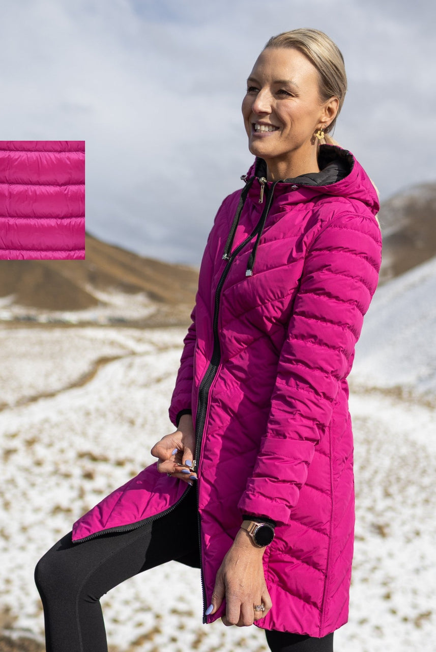 Woman wearing Moke - Arnie Reversible Packable Down Coat (ARNIE) in colour Black/Rose Violet on hill with snow in backgroumd.