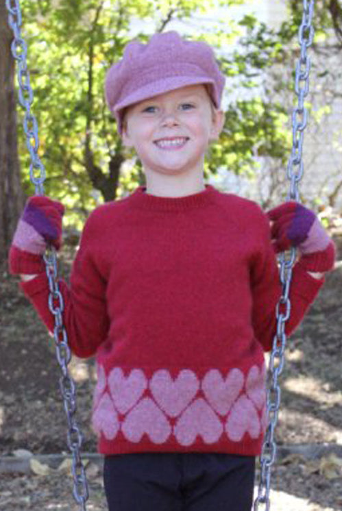 Girl by swing wearing Jumper in colour red.
