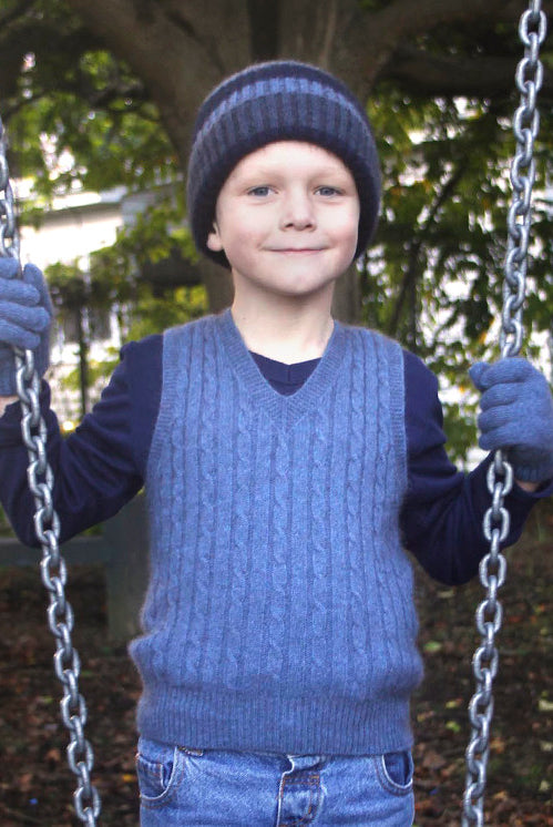 Boy standing by swing wearing light blue colour vest.