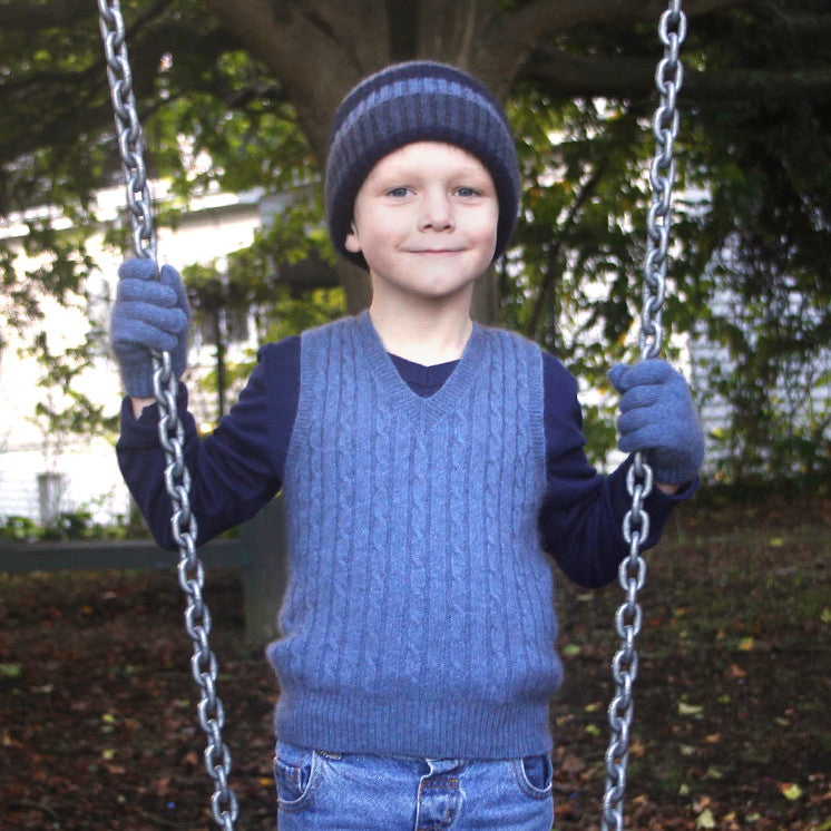 Boy standing by swing wearing light blue colour vest.