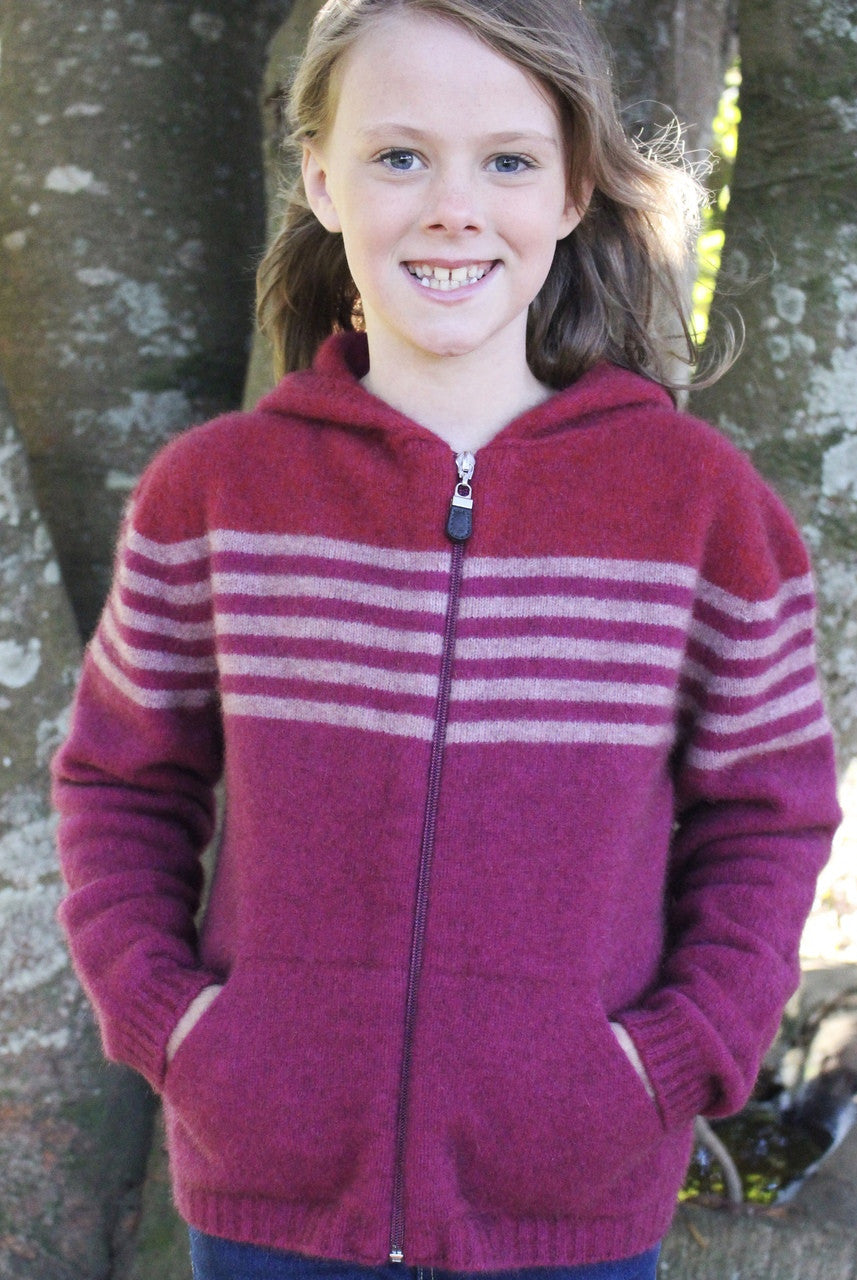 Girl standing wearing fuchsia colour striped hoodie.