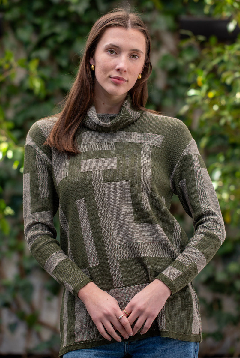 Woman wearing Country Laine - Cubist Jumper (CL0123L-IND2026) in the colour Olive/Chateau.