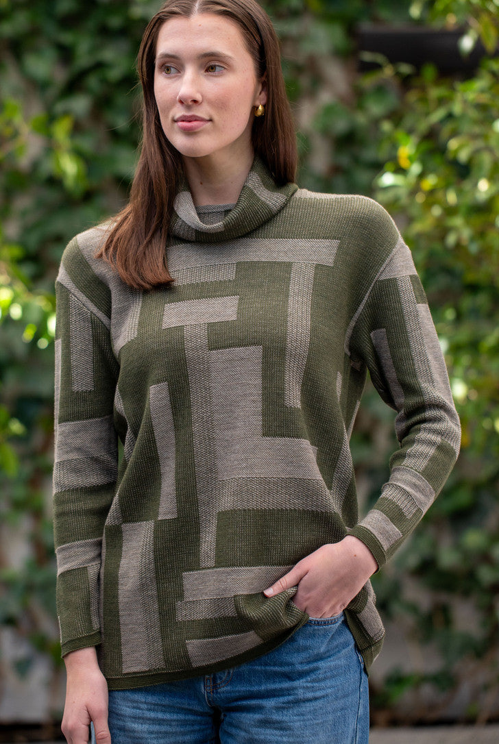 Woman wearing Country Laine - Cubist Jumper (CL0123L-IND2026) in the colour Olive/Chateau.
