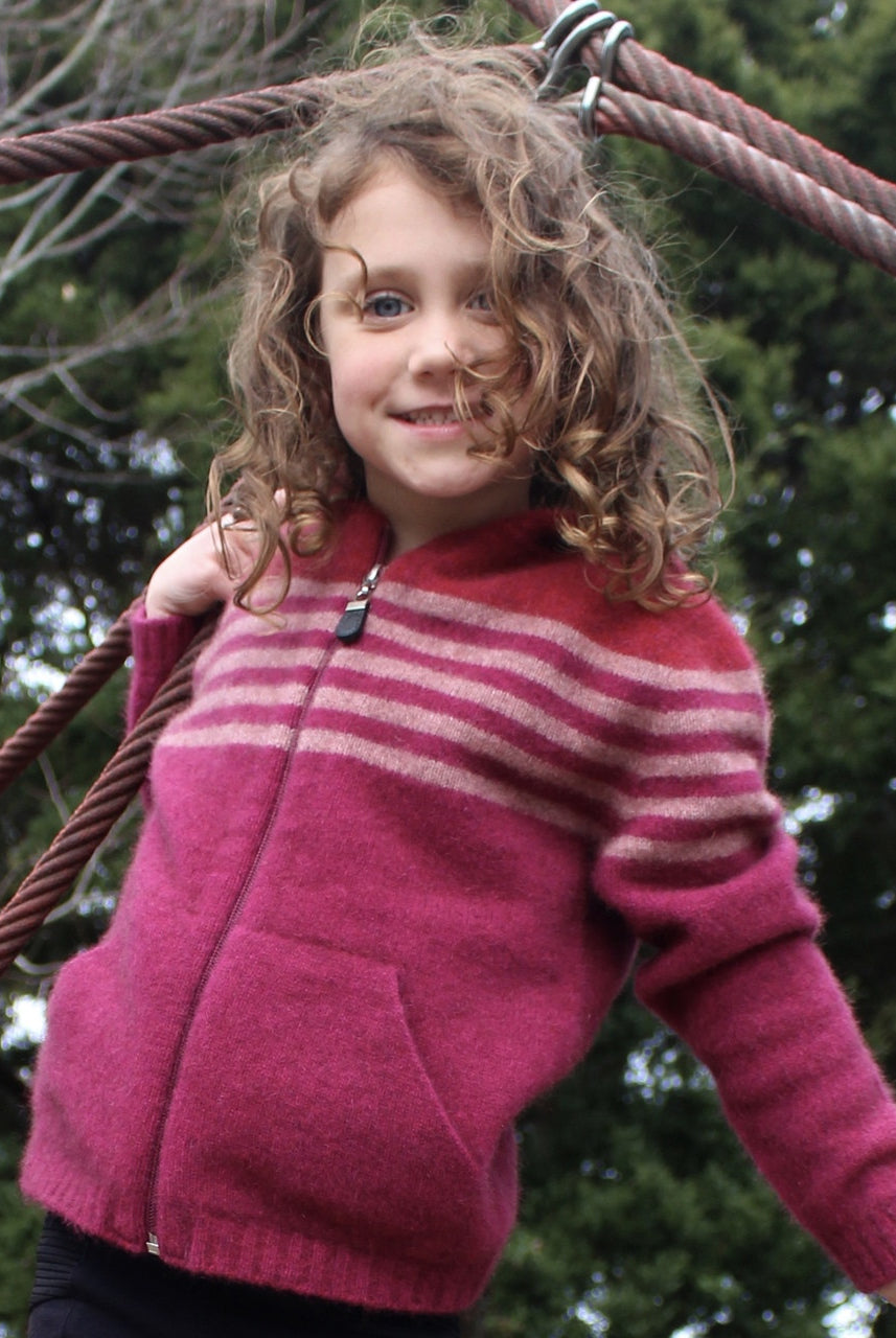 Girl leaning sideways wearing fuchsia colour striped hoodie.