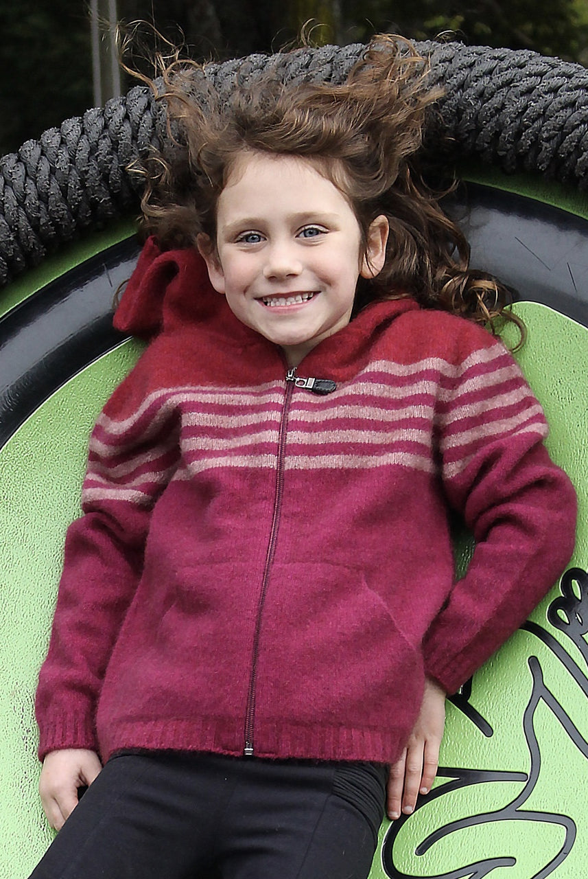 Girl leaning back wearing fuchsia colour striped hoodie.