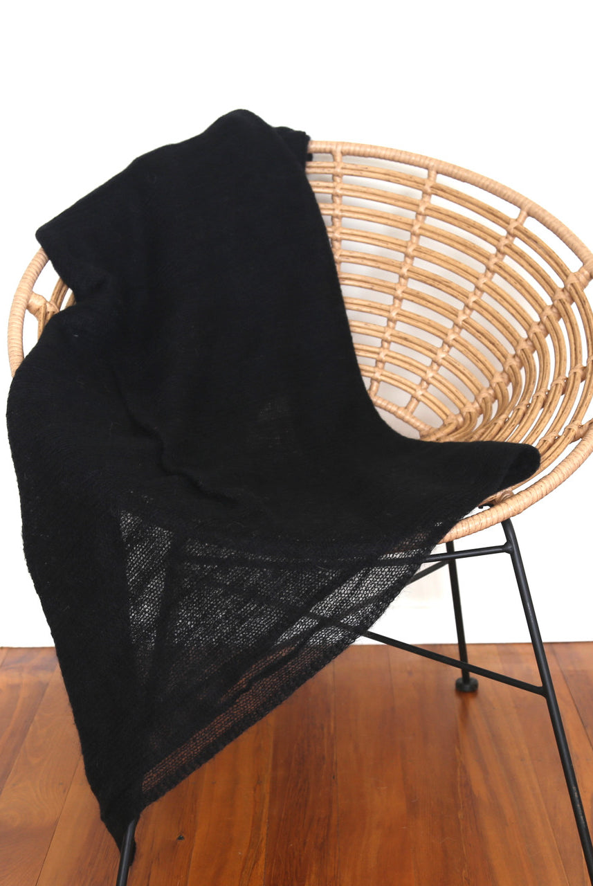 Black-coloured Knight Mohair Throw draped over chair.