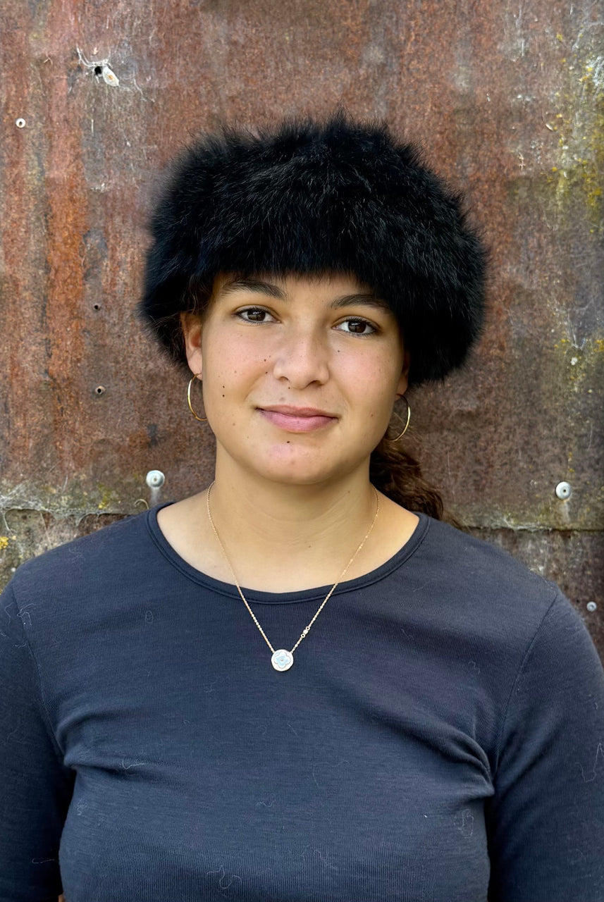 Woman standing wearing a Black coloured Four Peaks Classic Panelled Lambskin & Possum Fur Hat.