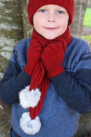 Boy wearing red colour scarf, beanie and glove set.