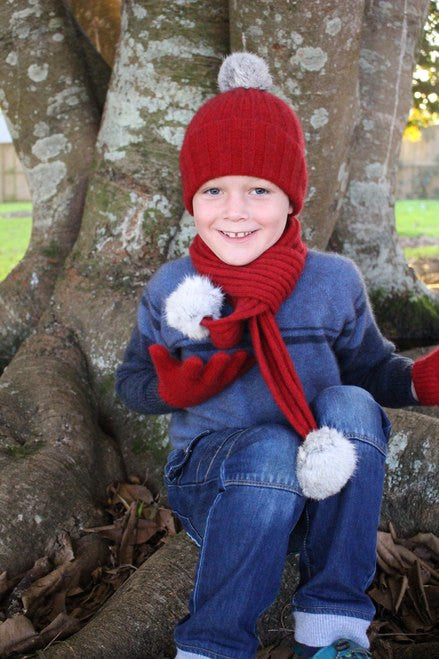 Child laughing wearing beanie. Colour Red