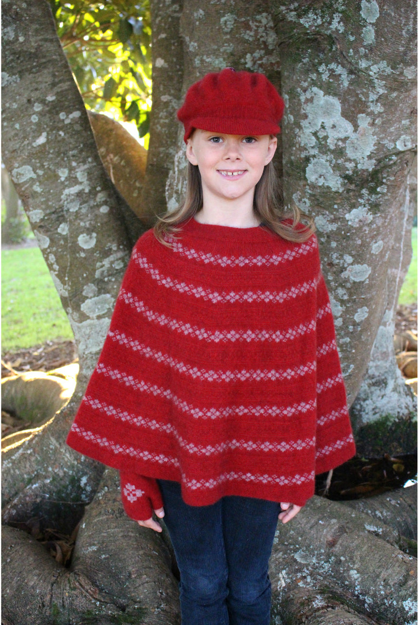 Girl standing wearing Poncho in colour red.