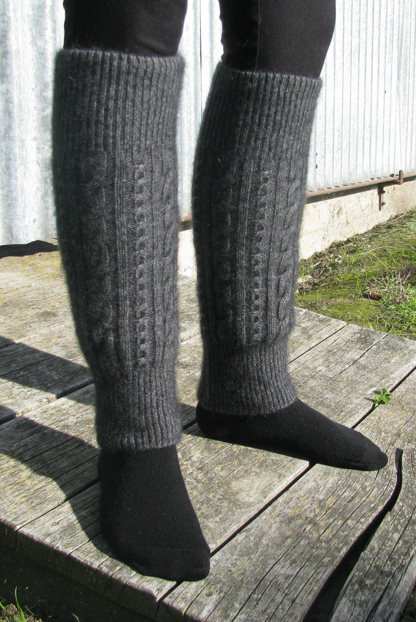 Close up of woman standing wearing grey Koru cable leg warmers.