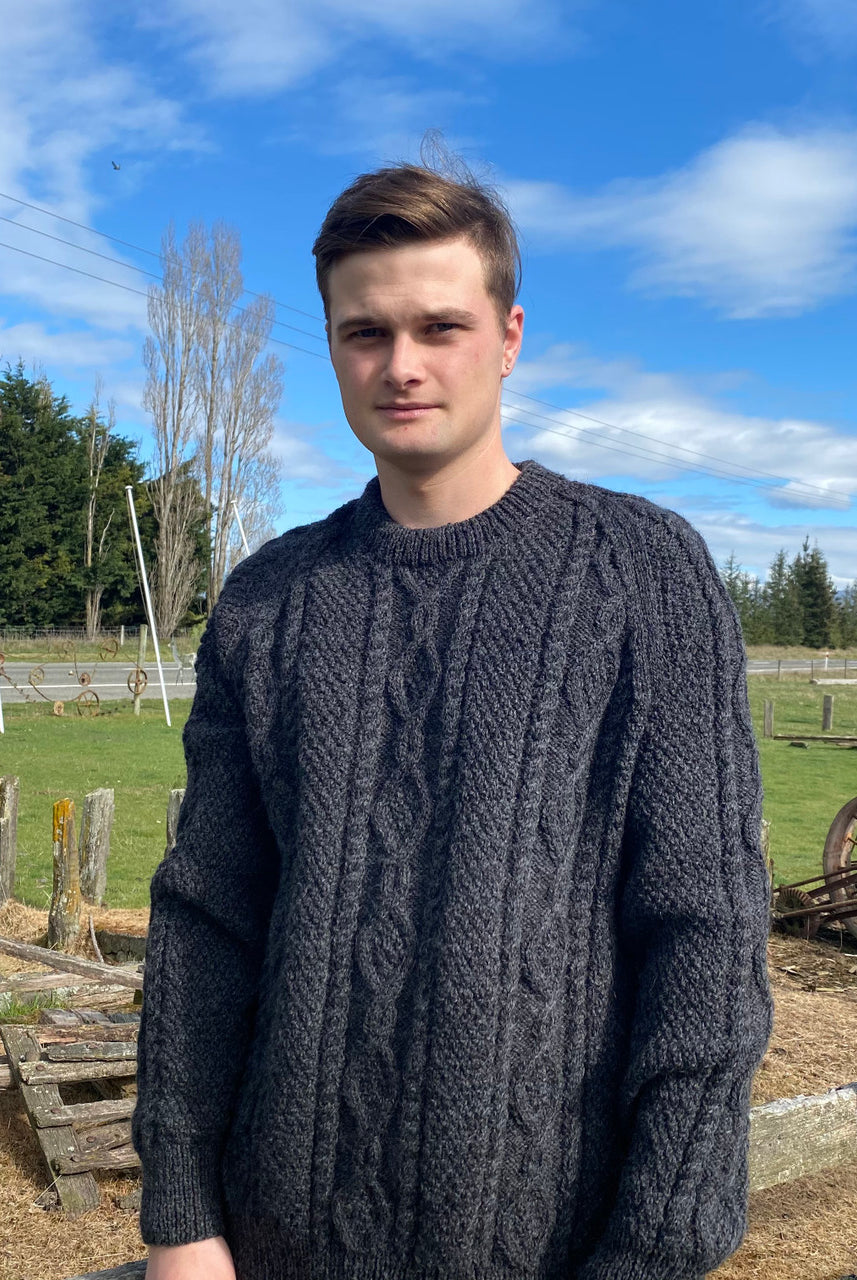 Man wearing Lesley Unisex Aran Wool sweater in the colour Charcoal.