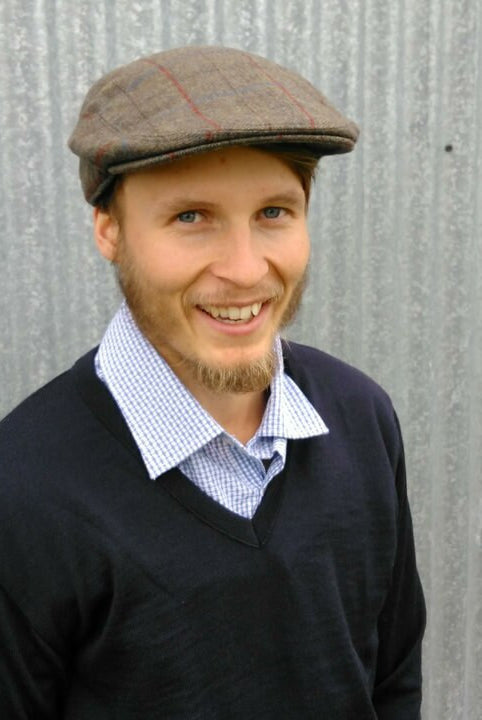 Man wearing Bingley Check Lambswool Tweed Cheesecutter hat in olive colour.