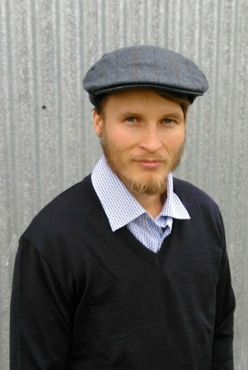 Man wearing blue coloured checkered plaid design, Cheesecutter hat.