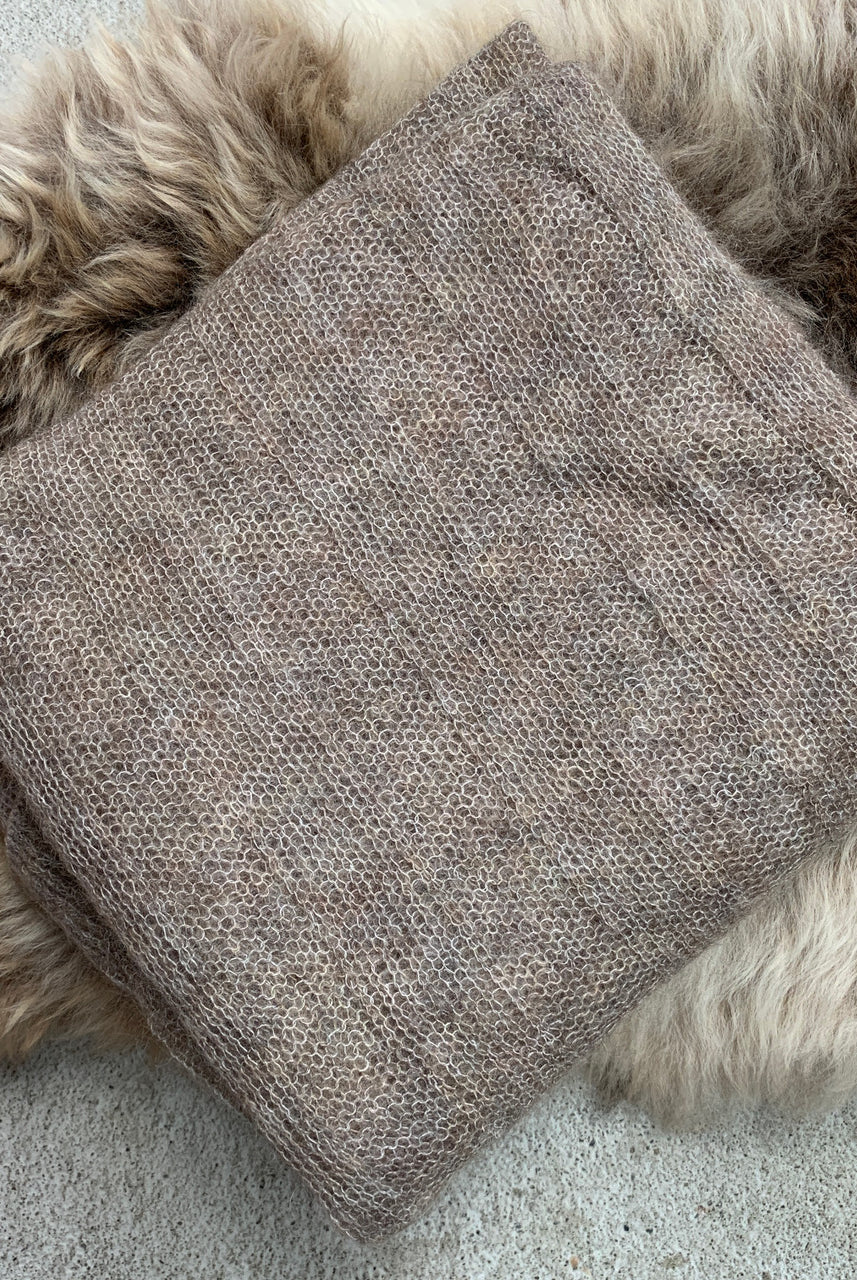 Folded fawn-coloured Knight Mohair Throw on fur rug.