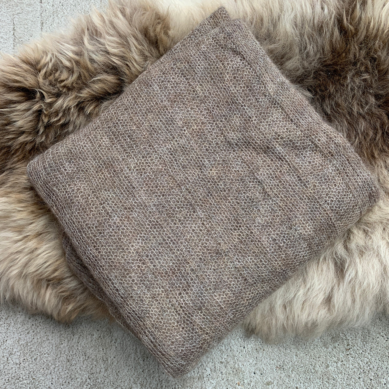 Folded fawn-coloured Knight Mohair Throw on fur rug.