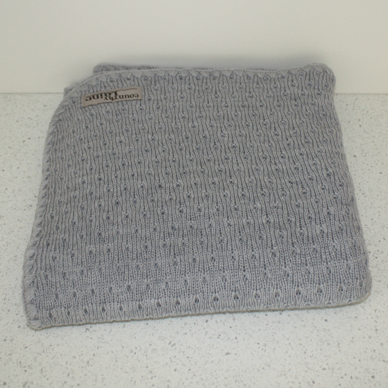 Grey coloured baby eyelet blanket.