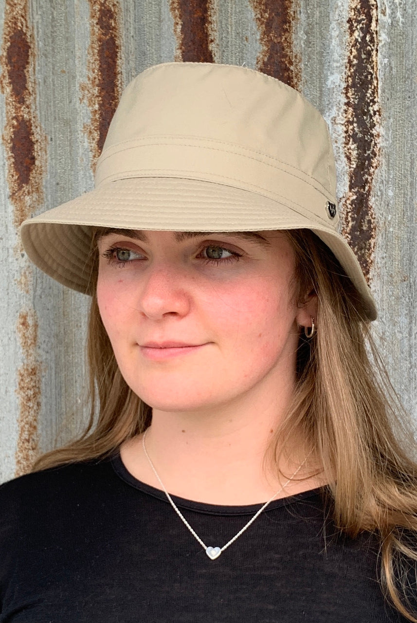 Woman wearing light sand coloured Hydroex rain hat.