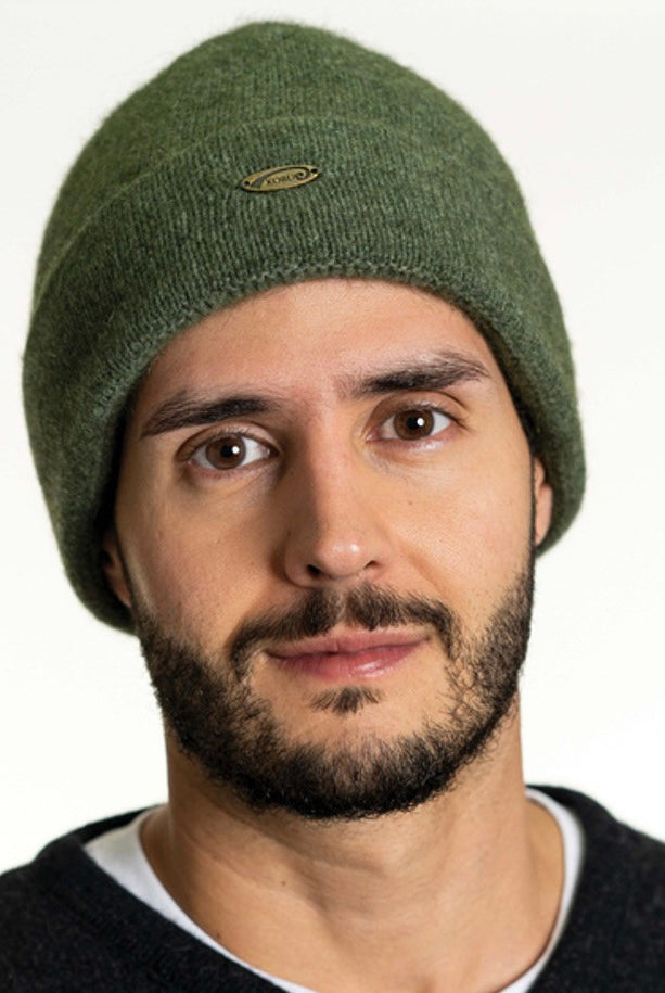 A man wearing an Moss-coloured Koru Merino and Possum Plain Beanie.