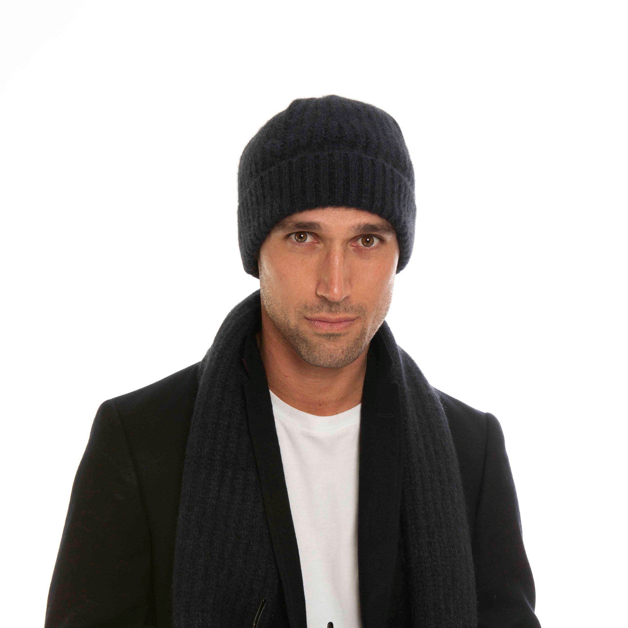 A man wearing an indigo-coloured Koru Merino and Possum Ribbed Scarf and Beanie Set.