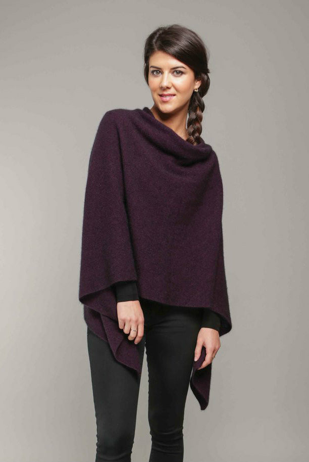 A woman wearing a grape-coloured Koru merino and possum Two Way Poncho.