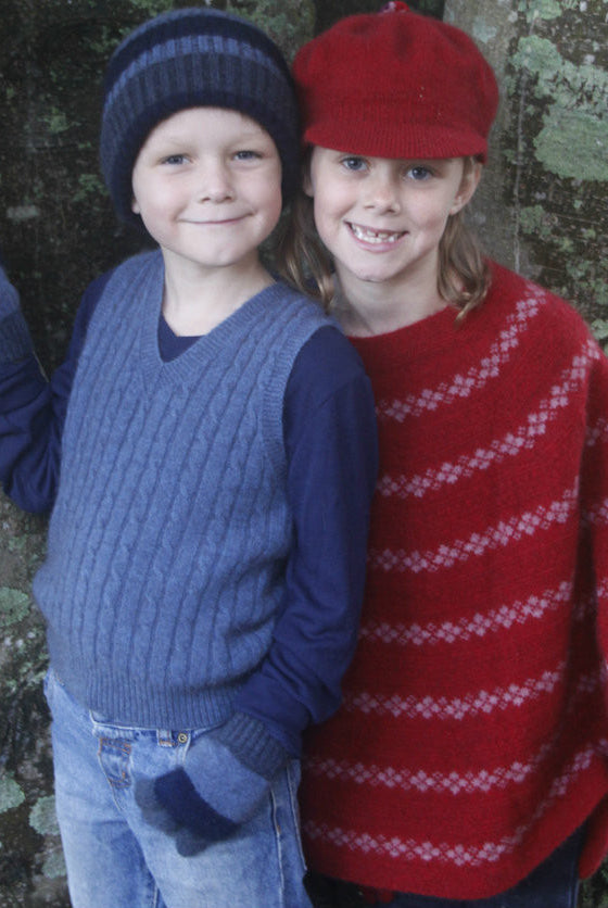 Girl wearing Poncho in colour red, next to boy.
