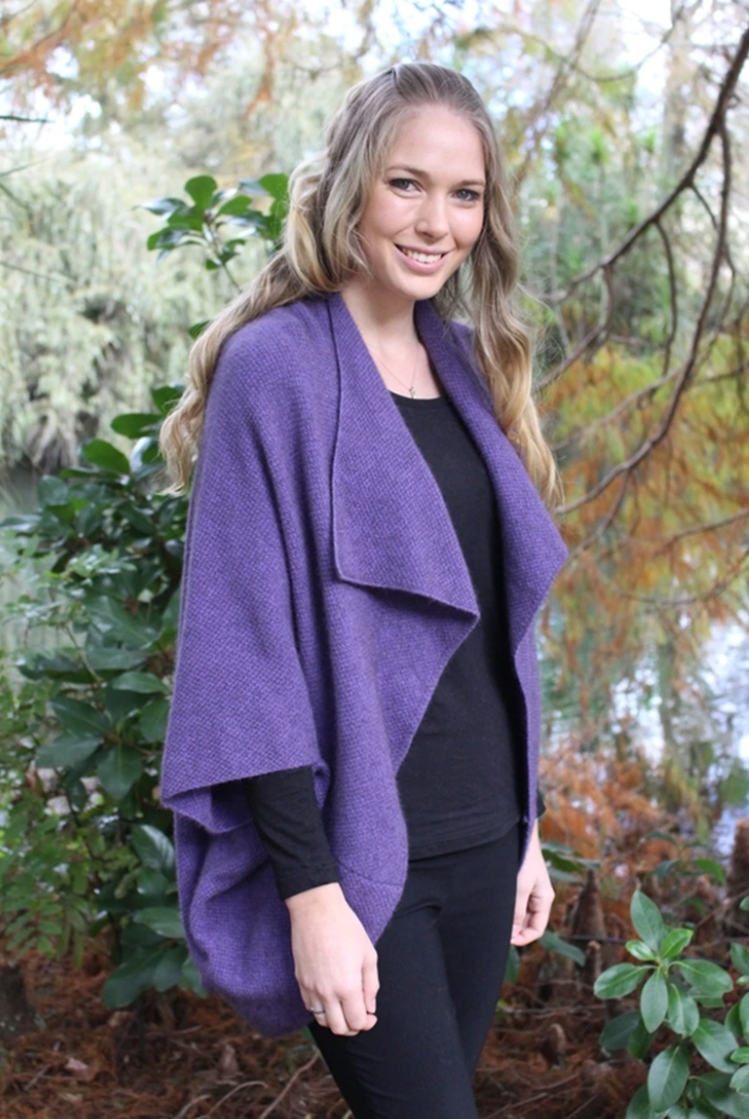 Woman wearing Takahe cape in colour Heather