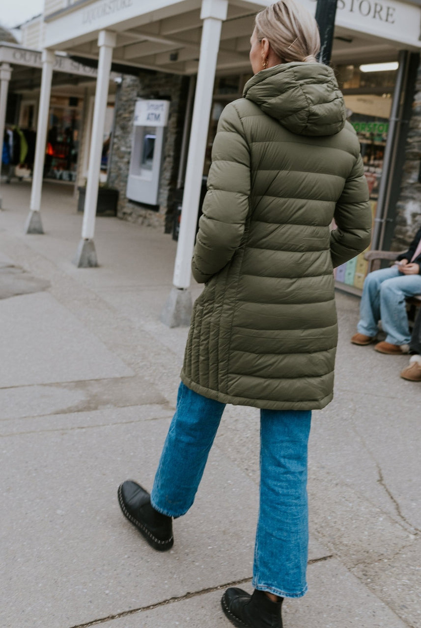 Woman wearing Moke - Sydney Cloud Touch 90/10 Down Coat (SYDNEY) in the colour Black while walking down a street.