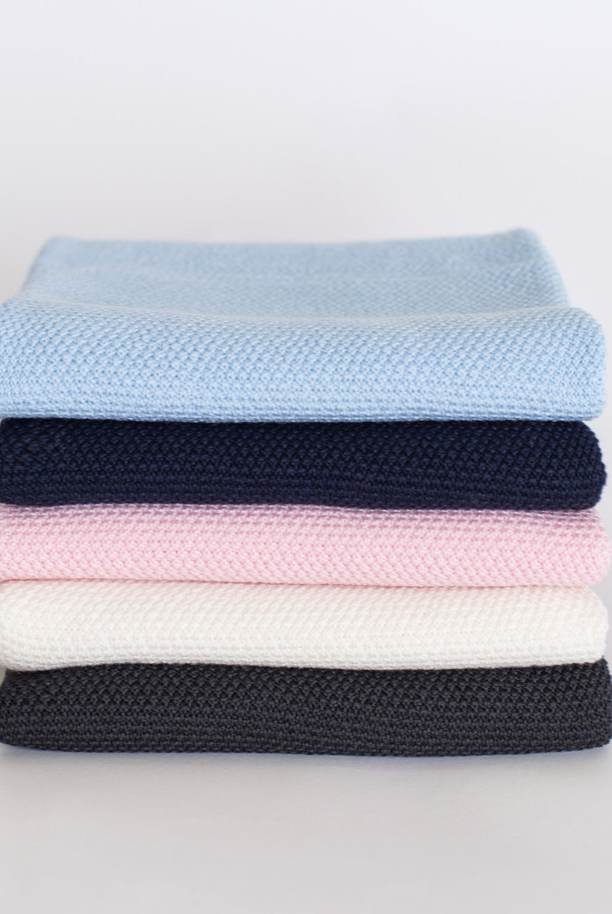 Stack of folded different coloured baby blankets.