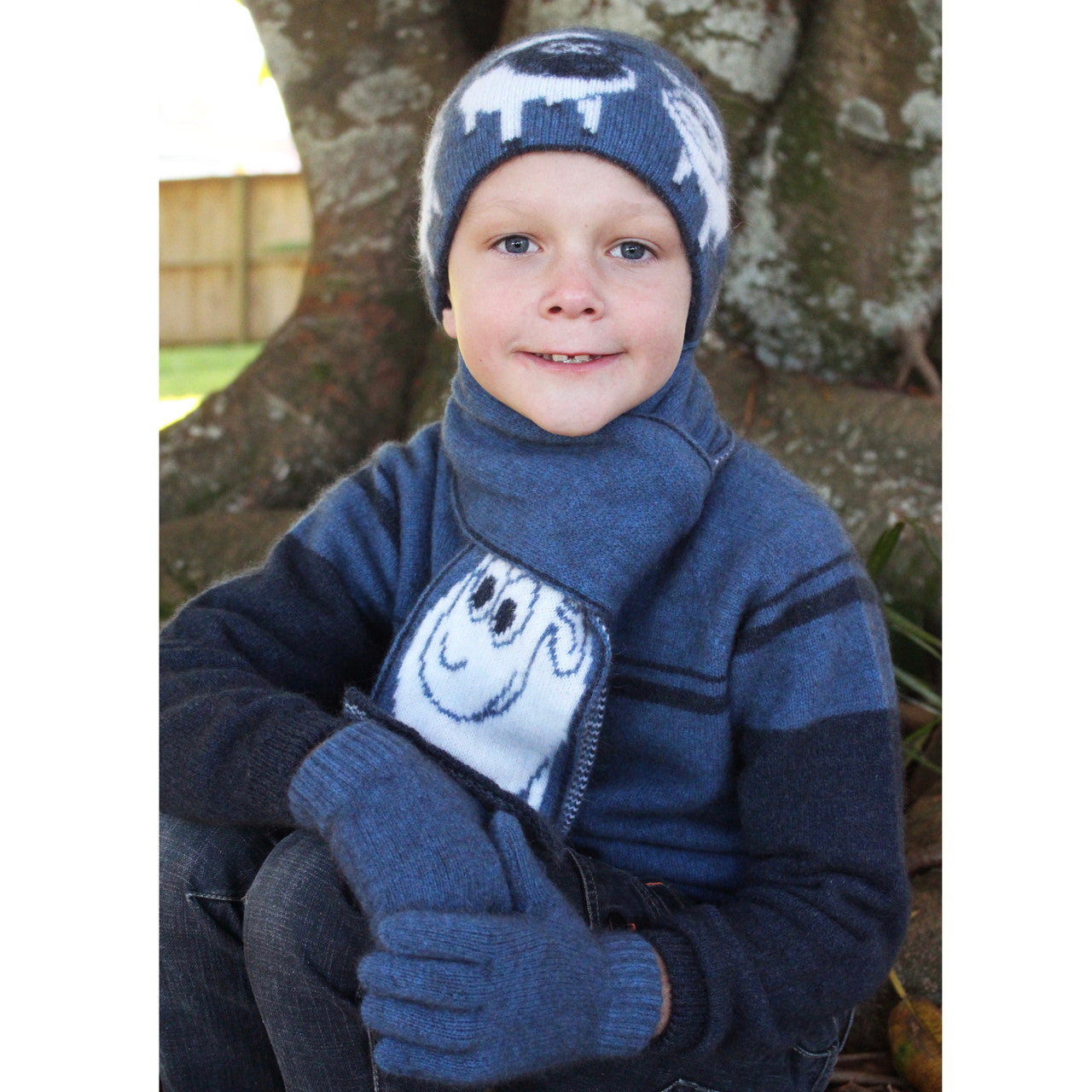 Boy sitting facing forward wearing Beanie in colour blue.