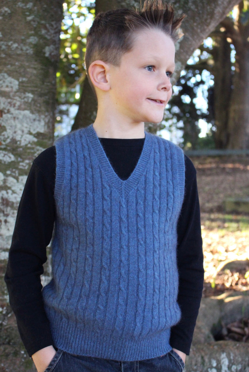 Boy facing right wearing light blue colour vest.