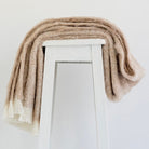 Alpaca fleece throw in sand colour draped on chair.