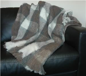 Alpaca fleece throw in Plateau colour draped on couch.