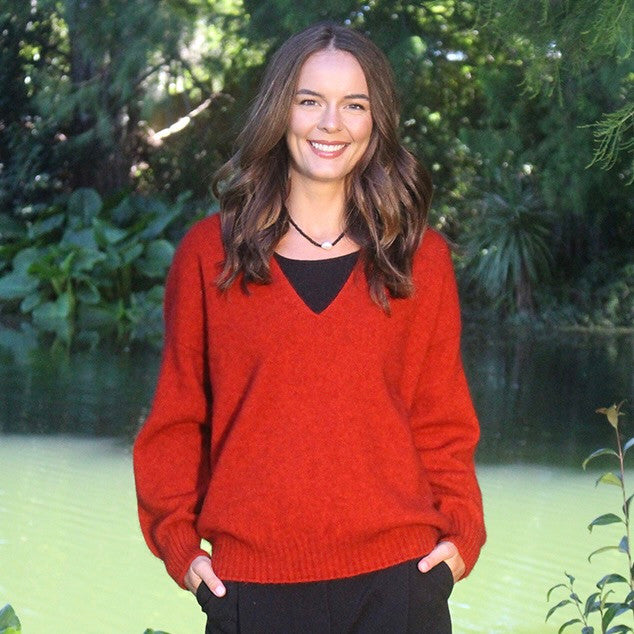 Woman wearing the Lothlorian - Merino & Possum Cavern V Neck Jumper (9789) in the colour Pumpkin.